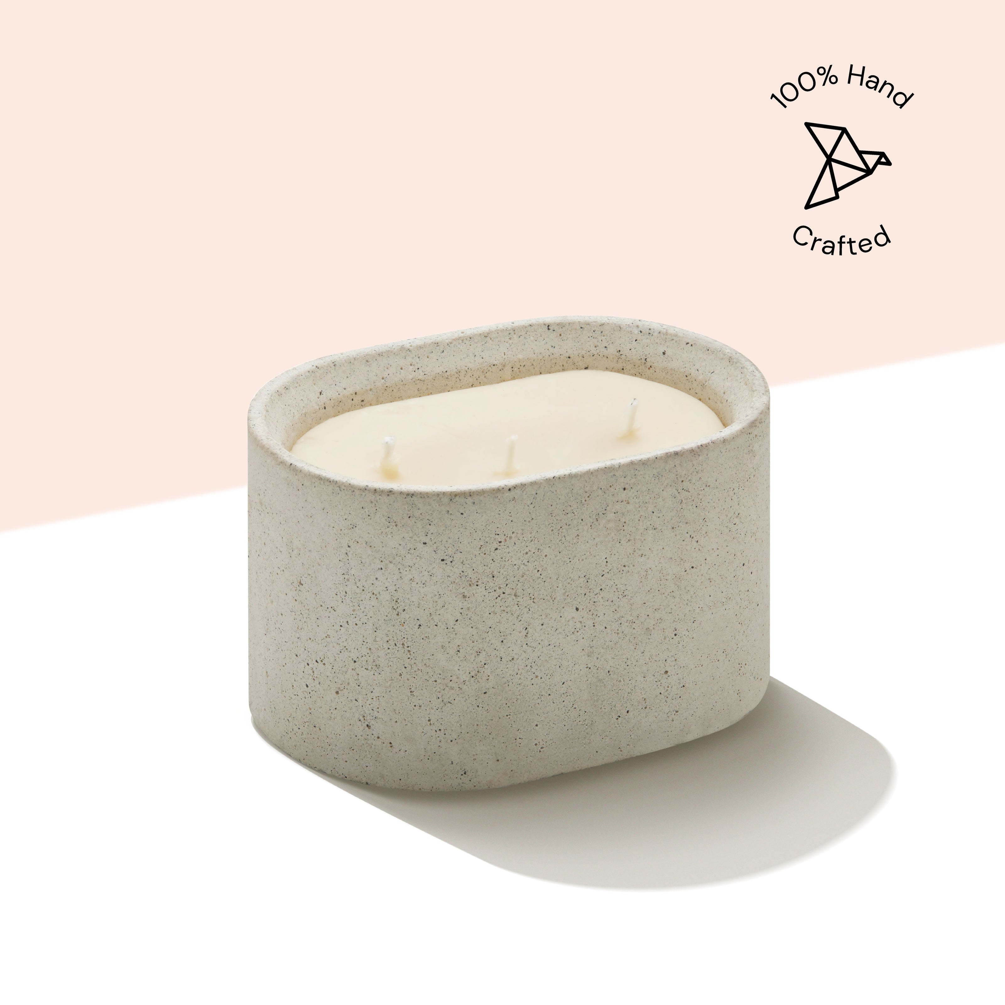 Eraya Aesthetic Cement Soy wax candle holder with a lit candle on a light pink background, featuring '100% Hand Crafted' icon.