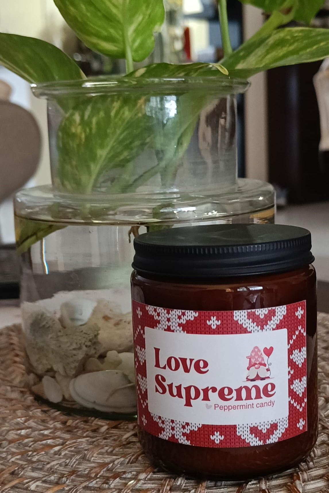 Jar labeled 'Love Supreme' with a plant in the background